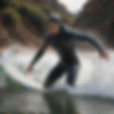 Surfer catching a wave in the Element Hoodie.