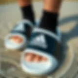 Adidas Slides Design Details Adidas black and white slides on a textured surface