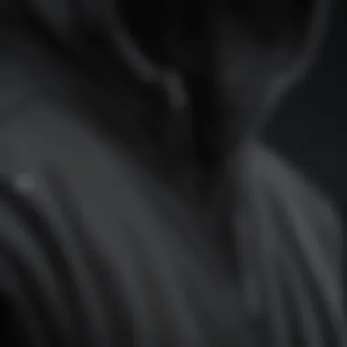 Detailed View: Fabric and Design of the Black Zip Hoodie A close-up of the black zip hoodie emphasizing its fabric and design