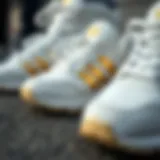 Close-up of white and gold Adidas shoes highlighting design details