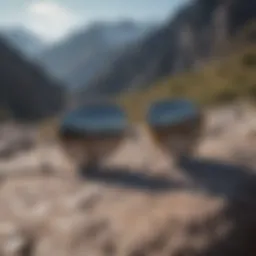 A close-up view of gold frame sunglasses on a rocky mountain backdrop